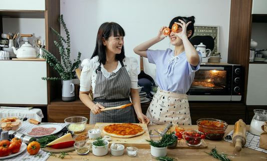 A photo of 2 people making a sweet potato pizza